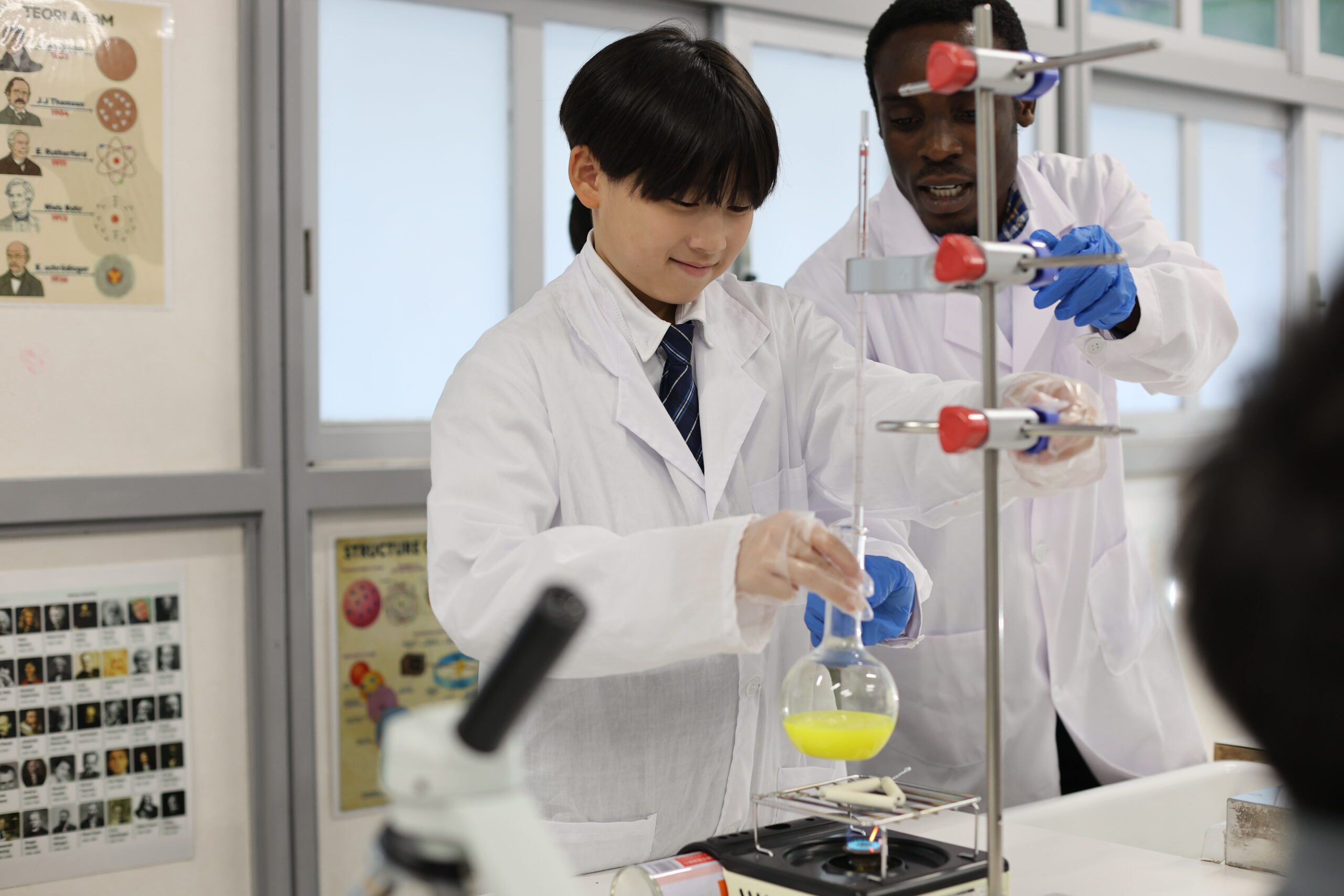 Junior Secondary School Students perform a science experiment with their teacher at OWIS OSAKA