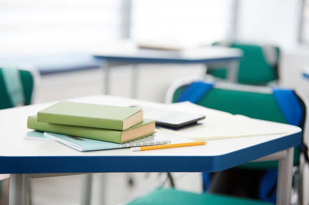 教室の机の上に置かれた教科書やノート、鉛筆