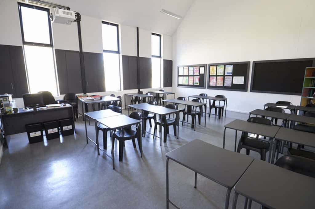 窓から光が差し込む、誰もいない学校の教室