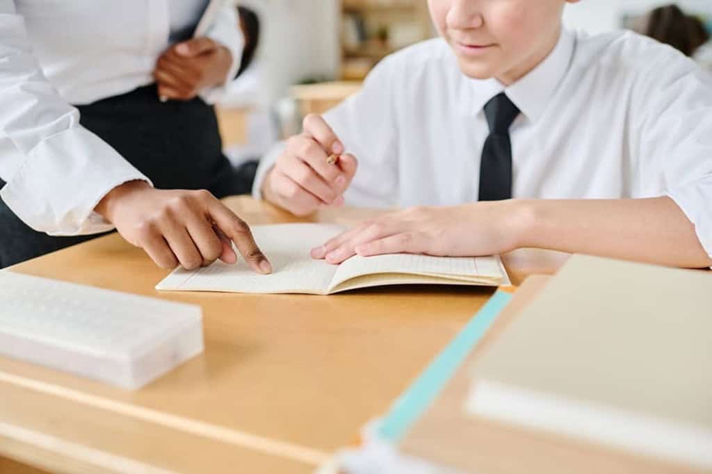 教師が生徒のノートを指差しながら指導をしている様子