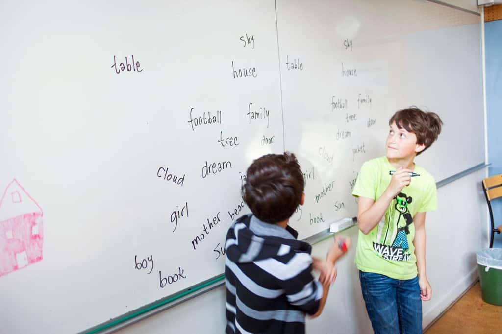 ホワイトボードに英単語を書く小学生