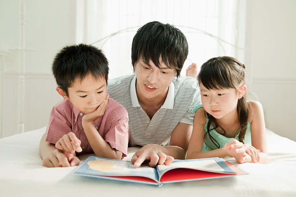 父親と絵本を読む子どもたち
