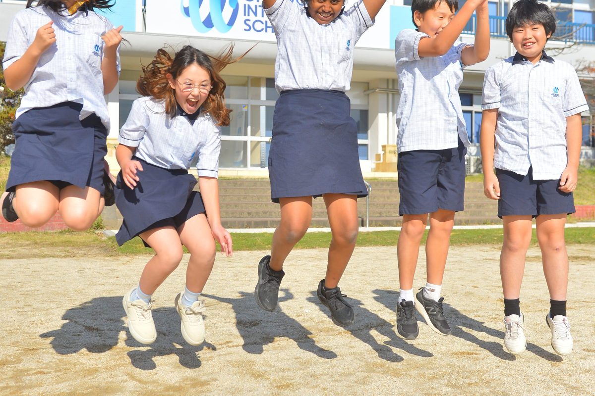 Students Jumping, having fun in the yard at One World International School Tsukuba