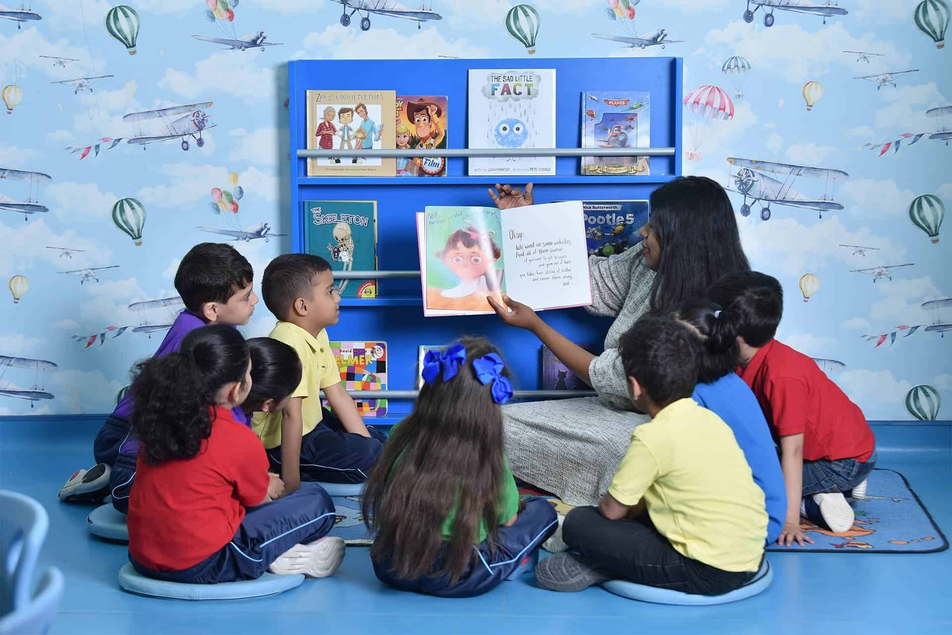 Smiling students at OWIS Riyadh engaged in a reading activity
