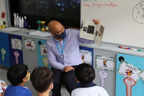 622c114c4aaa9245e763d9ba_Mark Renie, OWIS Head of School, reading to Early Childhood students in Book Week-p-500