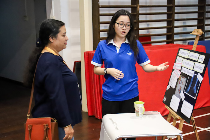 IBDP student explaining project in Theory Of Knowledge Exhibition at OWIS Nanyang, Leading International School in Jurong, Singapore