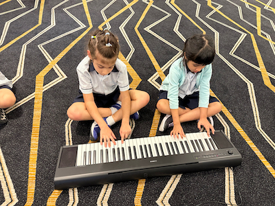 Primary School students engaging in music lesson at One World International School in Singapore | Suntec campus