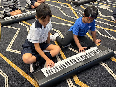 Primary School students at OWIS Suntec learning music | Well-rounded education at International School near Orchard