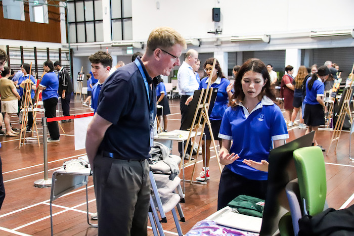 Students presenting their projects at the IBDP Theory of Knowledge Exhibition